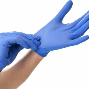 Two hands putting on purple latex gloves