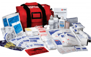 Large red bag for first responders first aid kit. The contents are layed out around the bag and include dressings, bandages, eyewash, cold compresses, and other first aid supplies.