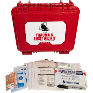Closed first aid kit with survival blanket, oval eyepad, all purpose sponges, chest seal, marker, and hand sanitizer laid out in front
