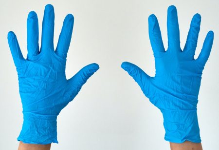 Two open hands displaying blue, latex gloves