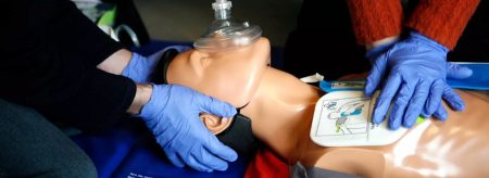 Hands on mannequin performing chest compressions for CPR